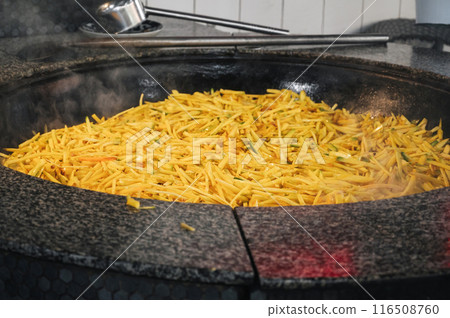 yellow carrots are stewed in a cauldron for cooking traditional Asian Uzbek pilaf in kitchen at a restaurant in Tashkent in Uzbekistan yellow carrots are stewed in a cauldron for cooking traditional Asian Uzbek pilaf in kitchen at a restaurant in Tashkent in Uzbekistan 116508760