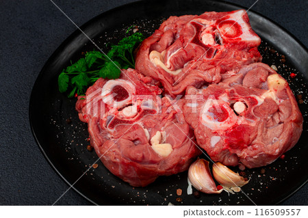 raw steak, calf's neck on the bone, fresh meat, on a black plate, top view, no people, raw steak, calf's neck on the bone, fresh meat, on a black plate, top view, no people, 116509557