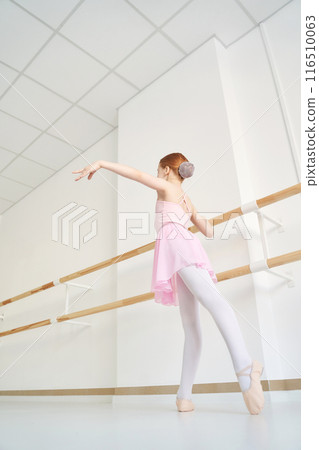 Young ballet girl at studio lesson. Training performance. Stretching exercise 116510063