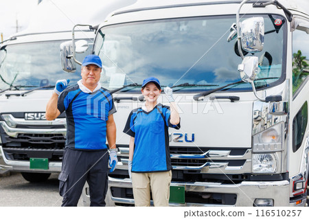 Male and female drivers standing in front of a truck 116510257