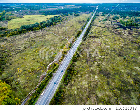 beautiful landscape of suburb field with track and trees on its 116510388