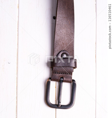 brown leather belt on wooden background brown leather belt on wooden background 116510461