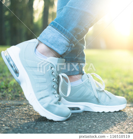 Person walking in gray running shoes, closeup 116510519
