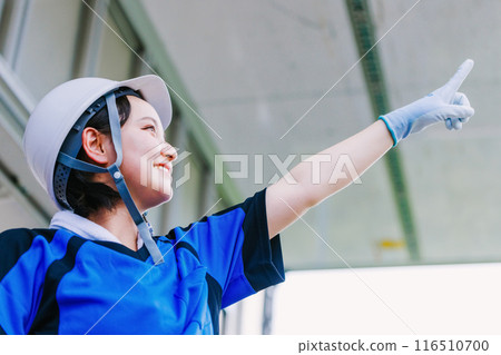 一名戴安全帽的女司機指著卡車的床上 一名戴安全帽的女司機指著卡車的床上 116510700