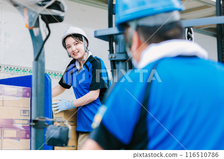 戴頭盔的工人用堆高機將貨物裝載到卡車上 戴頭盔的工人用堆高機將貨物裝載到卡車上 116510786