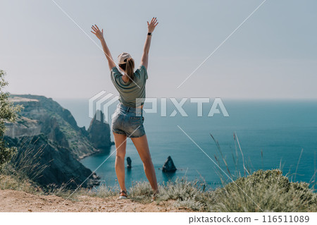 Woman's Triumphant Pose Overlooking the Sea 116511089