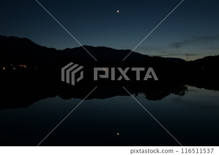 在北斗市白州町,傍晚的陽光出現一彎新月,倒映在已犁過、等待播種的稻田上。 在北斗市白州町,傍晚的陽光出現一彎新月,倒映在已犁過、等待播種的稻田上。 116511537