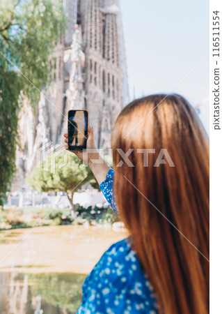 Tourists capturing photos of La Sagrada Familia. A girl on a trip takes pictures of a Barcelona. Travel banner Tourists capturing photos of La Sagrada Familia. A girl on a trip takes pictures of a Barcelona. Travel banner 116511554