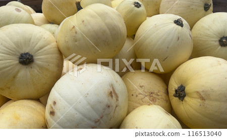 A close-up shot of several pale yellow pumpkins, showcasing their unique shapes and textures A close-up shot of several pale yellow pumpkins, showcasing their unique shapes and textures 116513040