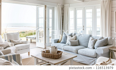 Interior of a living room with white walls, sofa and cushions. Sitting room in coastal cottage with sea view. Luxury lounge room 116513979