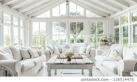 Interior of a living room with white walls, sofa and cushions. Sitting room in coastal cottage with sea view. Luxury lounge room Interior of a living room with white walls, sofa and cushions. Sitting room in coastal cottage with sea view. Luxury lounge room 116514478