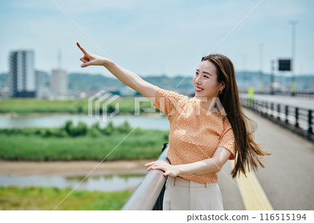 Surprised young woman pointing 116515194