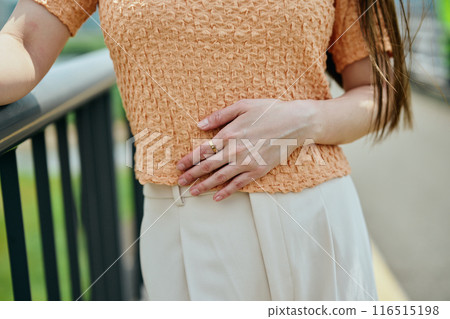 Young woman putting her hand on her stomach 116515198
