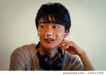 Young man with headphones around his neck 116515709