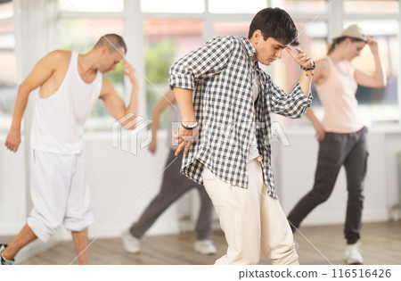 Young guy practicing hip hop slide moves in training hall Young guy practicing hip hop slide moves in training hall 116516426