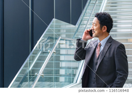 Middle-aged business person talking on a smartphone in the office 116516948