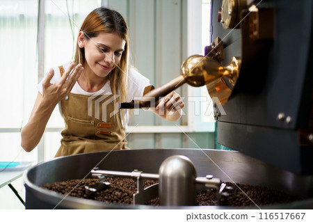 Professional coffee roaster working with modern automated roasting machine in the coffee roasting factory. Food and beverage business concept. Professional coffee roaster working with modern automated roasting machine in the coffee roasting factory. Food and beverage business concept. 116517667