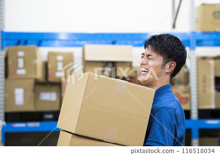 Young man working in a warehouse, hard work Young man working in a warehouse, hard work 116518034