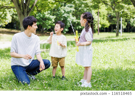 父母和孩子在清新的綠色公園玩泡泡 116518465