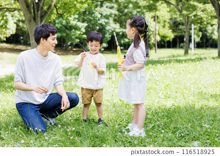 父母和孩子在清新的綠色公園玩泡泡 父母和孩子在清新的綠色公園玩泡泡 116518925