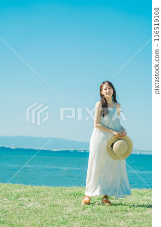 A woman in a dress enjoying vacation at a resort A woman in a dress enjoying vacation at a resort 116519108