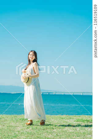 A woman in a dress enjoying vacation at a resort 116519109