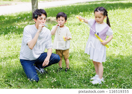 父母和孩子在清新的綠色公園玩泡泡 116519355