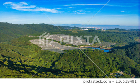 Mega solar power generation facility in the forest seen from a drone over the fresh greenery of Kada Miyama 116519491