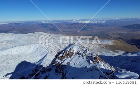 Spectacular snow-capped mountain range with valley and clouds in the background 116519581