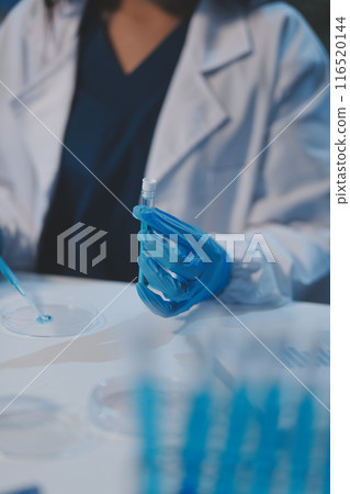 Group of dedicated scientist conduct chemical experiment in medical laboratory, carefully drop precise amount of liquid from pipette into test tube for vaccine drug or antibiotic development. Neoteric Group of dedicated scientist conduct chemical experiment in medical laboratory, carefully drop precise amount of liquid from pipette into test tube for vaccine drug or antibiotic development. Neoteric 116520144