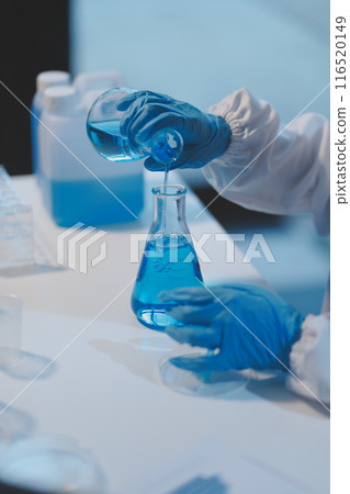Group of dedicated scientist conduct chemical experiment in medical laboratory, carefully drop precise amount of liquid from pipette into test tube for vaccine drug or antibiotic development. Neoteric Group of dedicated scientist conduct chemical experiment in medical laboratory, carefully drop precise amount of liquid from pipette into test tube for vaccine drug or antibiotic development. Neoteric 116520149