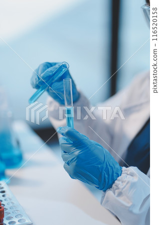 Group of dedicated scientist conduct chemical experiment in medical laboratory, carefully drop precise amount of liquid from pipette into test tube for vaccine drug or antibiotic development. Neoteric Group of dedicated scientist conduct chemical experiment in medical laboratory, carefully drop precise amount of liquid from pipette into test tube for vaccine drug or antibiotic development. Neoteric 116520158