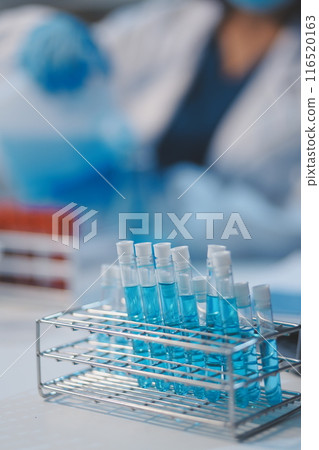 Group of dedicated scientist conduct chemical experiment in medical laboratory, carefully drop precise amount of liquid from pipette into test tube for vaccine drug or antibiotic development. Neoteric Group of dedicated scientist conduct chemical experiment in medical laboratory, carefully drop precise amount of liquid from pipette into test tube for vaccine drug or antibiotic development. Neoteric 116520163