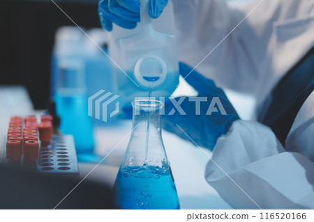 Group of dedicated scientist conduct chemical experiment in medical laboratory, carefully drop precise amount of liquid from pipette into test tube for vaccine drug or antibiotic development. Neoteric 116520166
