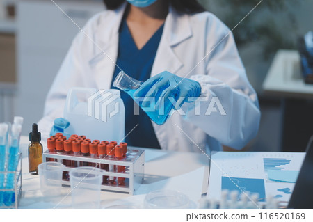 Group of dedicated scientist conduct chemical experiment in medical laboratory, carefully drop precise amount of liquid from pipette into test tube for vaccine drug or antibiotic development. Neoteric 116520169