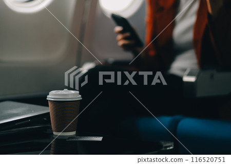 Stressed and serious young asian businesswoman remote working on the plane, suffering from headache and airsick during the flight. 116520751