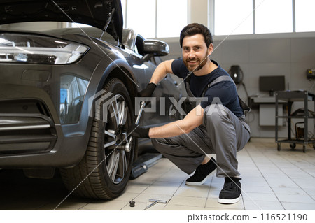 Mechanic working on car wheel in auto repair shop Mechanic working on car wheel in auto repair shop 116521190