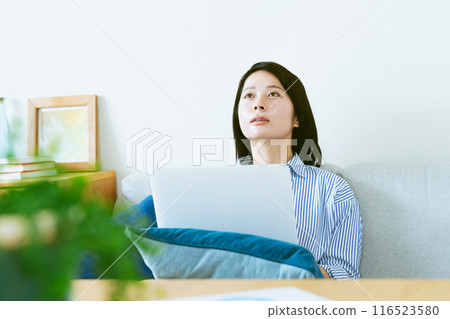 A woman who plays a personal computer in the living room 116523580