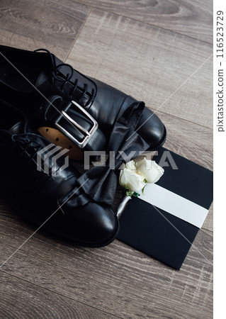 Men's groom's set. Dark shoes and belt. Nearby is an invitation letter 116523729