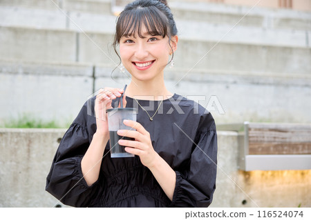 Female college student drinking coffee on a bench Female college student drinking coffee on a bench 116524074
