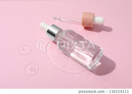 Hyaluronic acid in a bottle on a pink background. 116524211