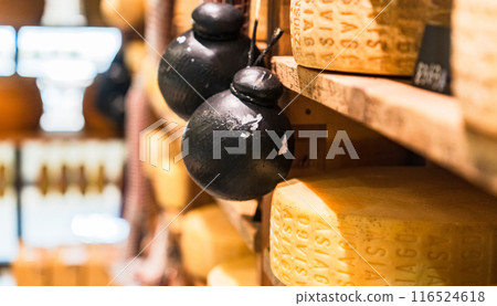 A cheese factory with rows of cheese holes [Image of a whole cheese] 116524618