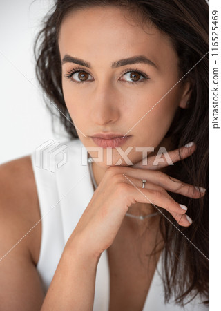 Calm beautiful girl posing in a new hot summer look. Wearing blue jeans and white waistcoat 116525469
