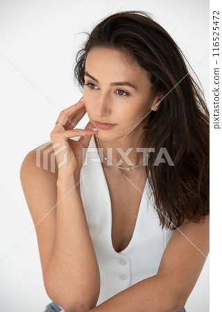 Calm beautiful girl posing in a new hot summer look. Wearing blue jeans and white waistcoat 116525472