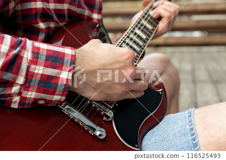A man plays a beautiful guitar close-up A man plays a beautiful guitar close-up 116525493
