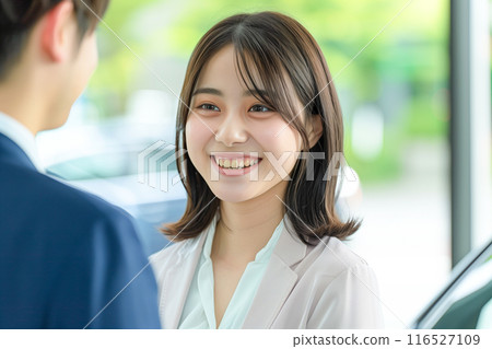 A woman welcoming customers at a car showroom_4 116527109