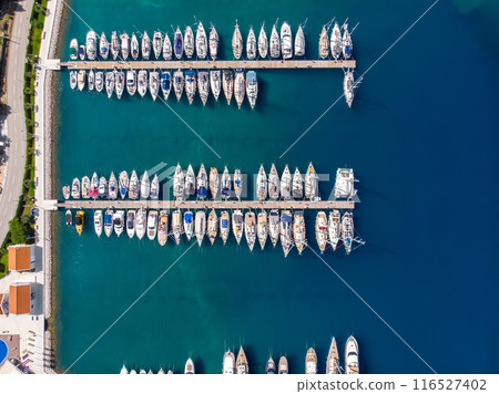 Scenic aerial view many yachts boats moored at Croatian bay harbor shore blue turquoise clear water at bright summer sunny day. Top above Mediterranean sea marina. Boat vessel charter service Scenic aerial view many yachts boats moored at Croatian bay harbor shore blue turquoise clear water at bright summer sunny day. Top above Mediterranean sea marina. Boat vessel charter service 116527402