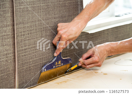 A craftsman laying wallpaper during the renovation of a used house A craftsman laying wallpaper during the renovation of a used house 116527573