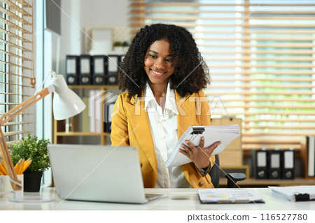 Portrait of successful African American businesswoman using laptop at her workplace Portrait of successful African American businesswoman using laptop at her workplace 116527780