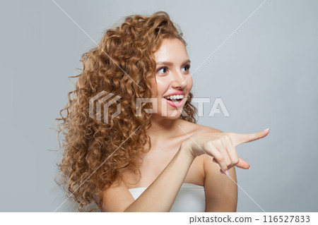 Happy excited woman pointing finger on white background with copy space Happy excited woman pointing finger on white background with copy space 116527833